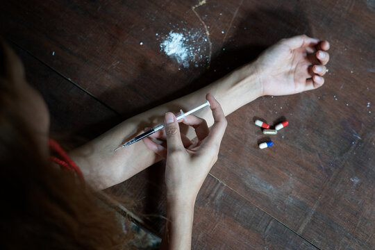 Drug addict woman hand with syringe using drugs.Narcotic; concept.