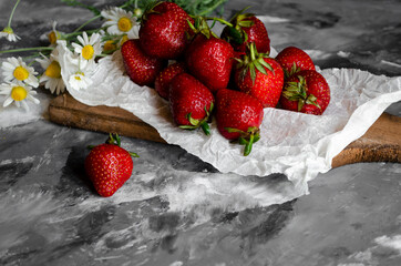 fresh strawberries on a light background with daisies