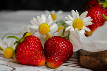 fresh strawberries on a light background with daisies