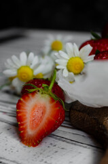 fresh strawberries on a light background with daisies