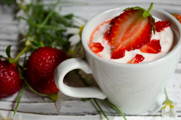 strawberry yogurt in a white cup with mint and fresh strawberries