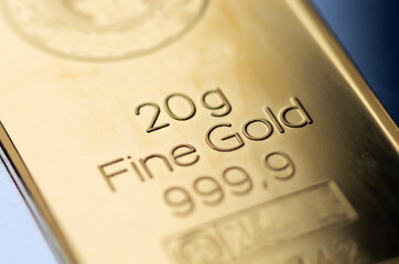 The surface of a minted gold bar weighing 20 grams. Selective focus.