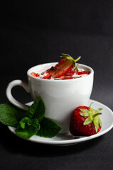 strawberry yogurt in a white cup with mint and fresh strawberries