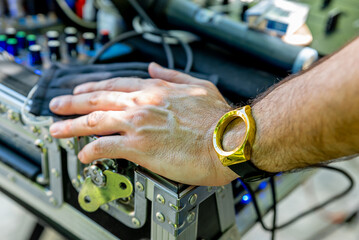 Italy. Hand and arm of a man near a DJ console and wearing a clock without a dial.