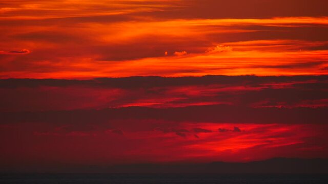 Red burning sky after sunset over sea ocean. Evening nature landscape