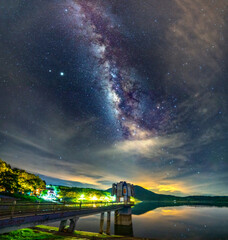 Night landscape at a hydroelectric dam with galaxies shining in the sky. This is power supply to...