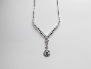 Elegant silver necklace with precious stones on a white background