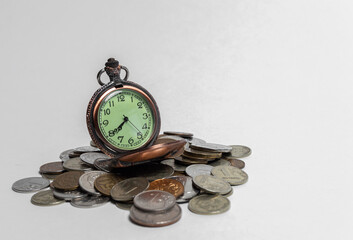 vintage pocket watches stand on a handful of coins