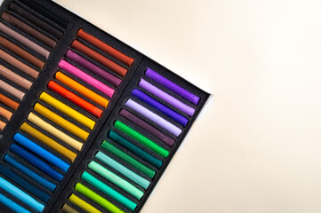 Crayons for drawing in a box on a white background. Dry pastels for artists.