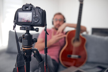 Guitarist making video lessons and tutorials for internet vlog website classes.