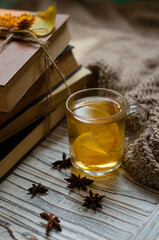 a stack of books on the table and a cup of tea with lemon