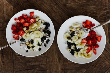 Oatmeal with banana, strawberries, raisins and nuts close-up.