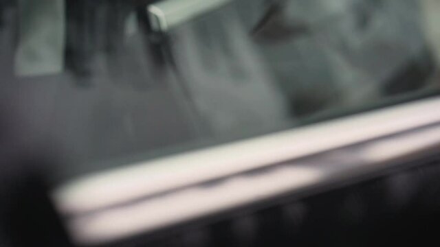 Hand opening handle on futuristic sports car and entering driver's seat close up slow motion