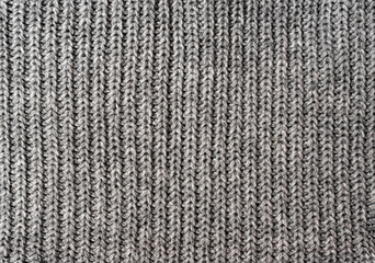 Gray knitted texture like on a woolen sweater or on a warm scarf. Type of knitting - stocking.
