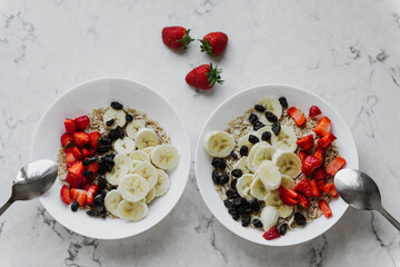 Oatmeal with strawberries, bananas and raisins close-up.