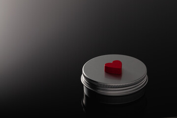Silver metal containers for cosmetics and a red heart
