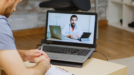 Man listening doctor advice on video call during global isolation.