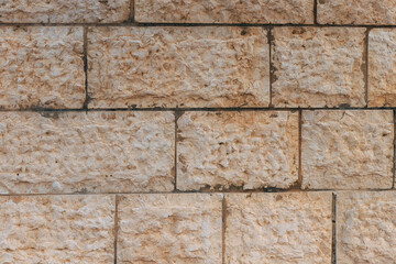 Jerusalem stone wall. Old wall made of the Jerusalem stone in Israel. Old restored wall. Fragment of an ancient stone wall in old Jerusalem in Israel. Vintage brick wall. Beige stone texture.
