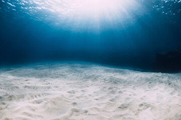 Ocean in the deep with white sandy bottom and underwater sun rays in Hawaii