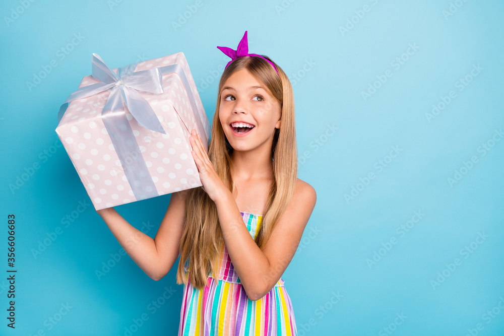 Canvas Prints Portrait of positive cheerful kid girl hold big gift box she get receive anniversary shake want know what inside wear stylish trendy outfit isolated over blue color background