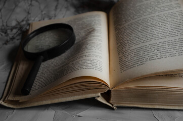 a book on a table with a magnifying glass
