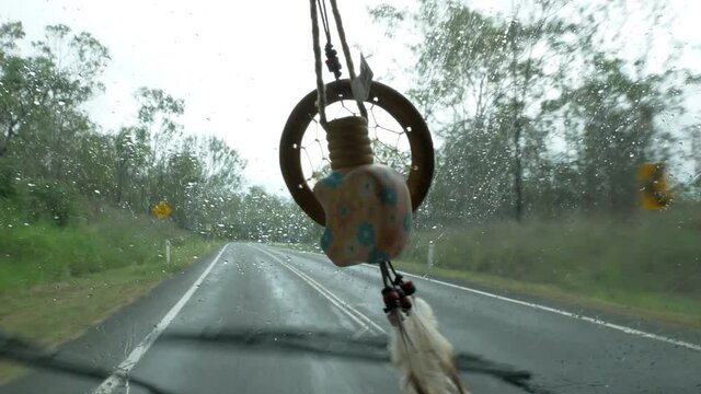 Dreamcatcher in van driving on a rainy day in Queensland Australia