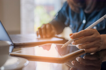 Business woman hands holding electronic pen ( stylus pen ) and working on  digital tablet  with...