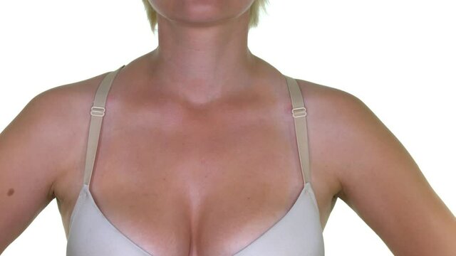 Attractive young woman with large natural,breasts corrects bra straps. Close up of the heavy big breasts of a woman in a big bra.
