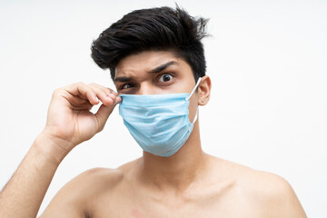 Young handsome boy giving creepy expressions while wearing a blue mask