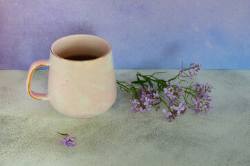Obraz na płótnie Canvas Minimalism. Purple background for the text. Ceramic coffee mug and lilac spring flowers with copy space text