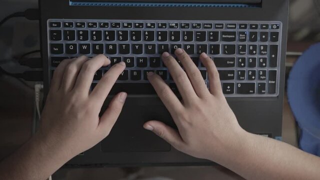 Man's Hands Typing on Laptop With Fingers Running on Keyboard, Top View