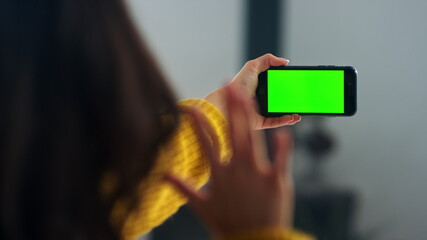 Brunette woman talking on video call indoor. Girl touching hair at online chat