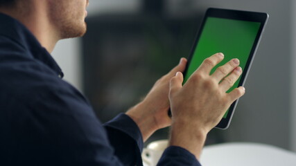 Cheerful male professional waving while video call with green screen pad cell.