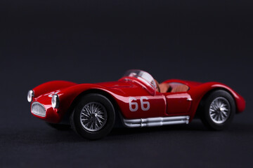 Fototapeta na wymiar Classic red sport car model scale on black background