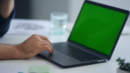 Man typing on laptop with green screen. Business man hands surfing internet.