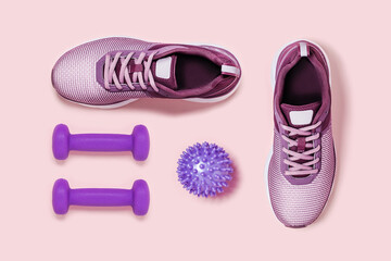 Train at home. Sports equipment on pink background. Sneakers and dumbbells.