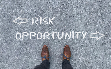 Top view on a man standing in front of the words "Risk" and "Opportunity" with arrows pointing to the left and right side of the picture