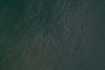 aerial drone bird view shot of the calm sea surface with transparent turquoise blue water and small waves forming beautiful textures, patterns, shapes. Sri Lanka