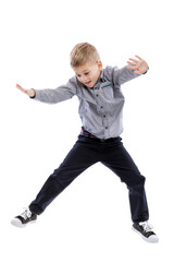 A little boy in jeans and a shirt is jumping. Isolated on a white background. Vertical.