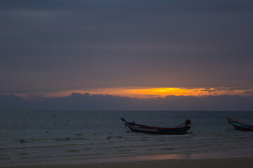 Naklejka premium Barca de Koh tao, Tahilandia, en el mar con nubes y luz de atardecer