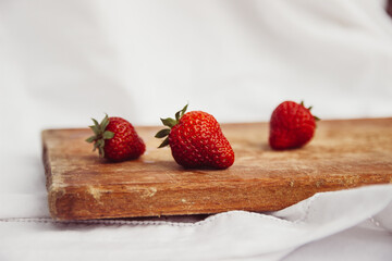 strawberries on a wooden board and a white background