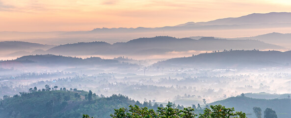 Landscape misty valley covered hills in the morning in the highlands, where the mild climate is suitable for cultivation of vegetables and fruit