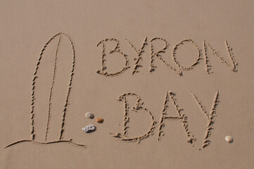 Surf board and Byron Bay inscription in the sand