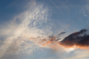 Naklejka na ściany i meble Light and dark clouds at sunset with blue sky background