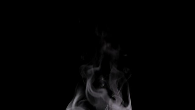 White steam spins and rises from the pan. White smoke rises from a large pot, which is located behind the frame. Isolated seamless loop black background.