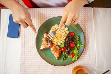 red fish fillet with a side dish of herbs and tomatoes on a plate