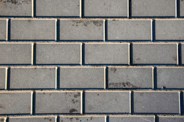 Background image. Тexture of paving slabs. Text space. Texture for the exterior. Cracks on the paving slabs. Top view. gray paving tiles.Wallpaper.