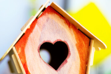 Wooden diy birdhouse, heart-shaped window, yellow background