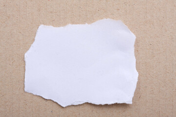 A torn piece of White Paper a brown paper cardboard. Copy Space. 