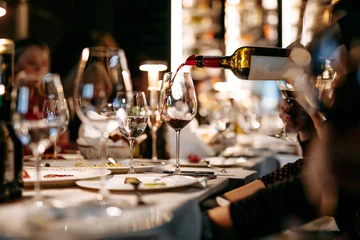 Tuinposter Close up of wine tasting at restaurant during evening time © Tymoshchuk